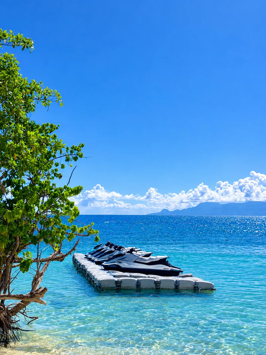 Jet skis amarrés au ponton flottant de la base Atmosphère au Club Med, Sainte-Anne, dans une eau turquoise